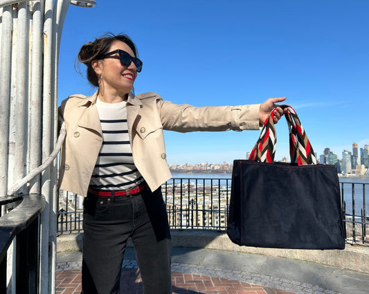 Black faux suede tote bag featuring vibrant handwoven Wayuu straps, blending Colombian craftsmanship with a modern everyday design.
