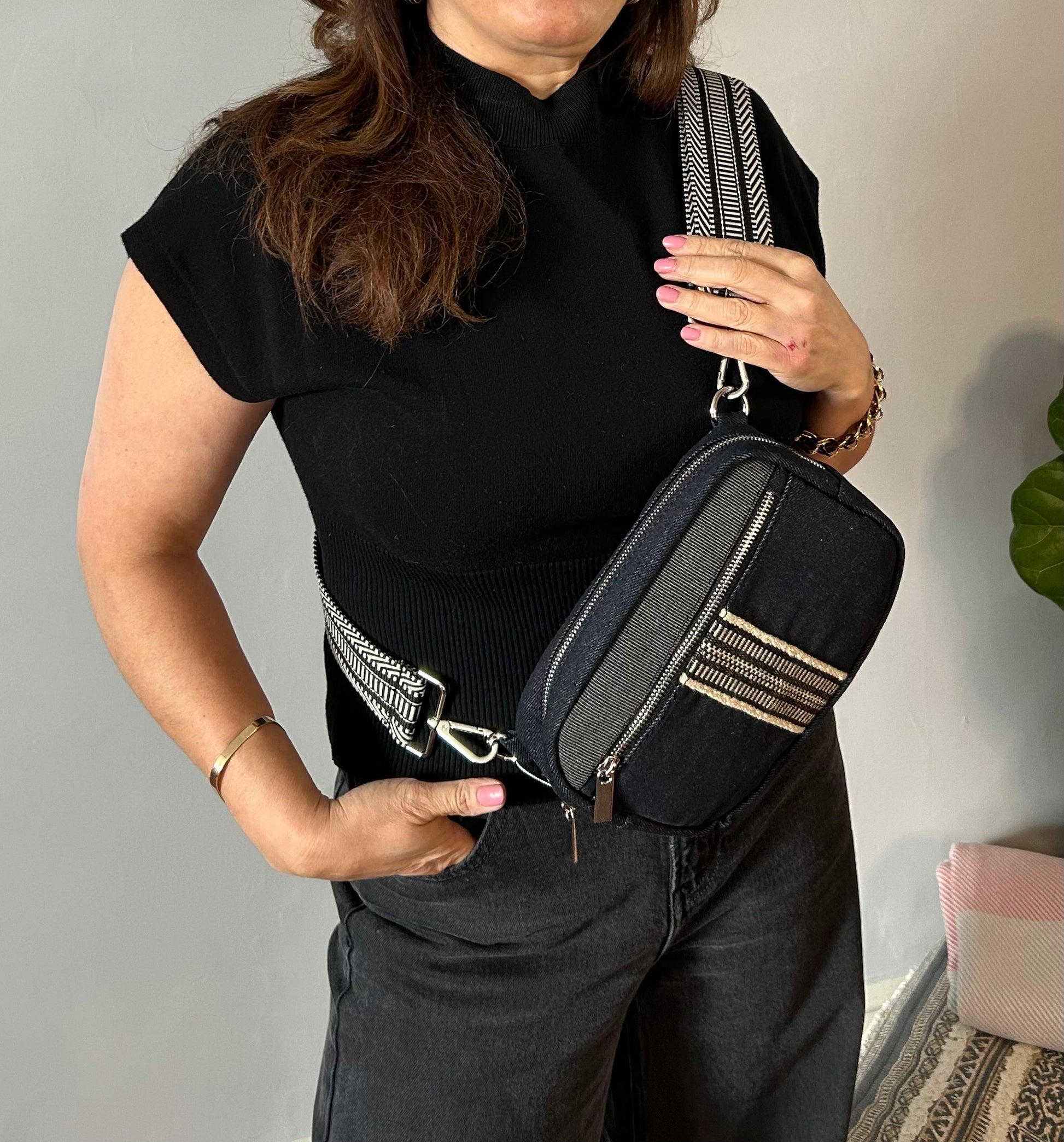 Black denim sling bag with colorful web.