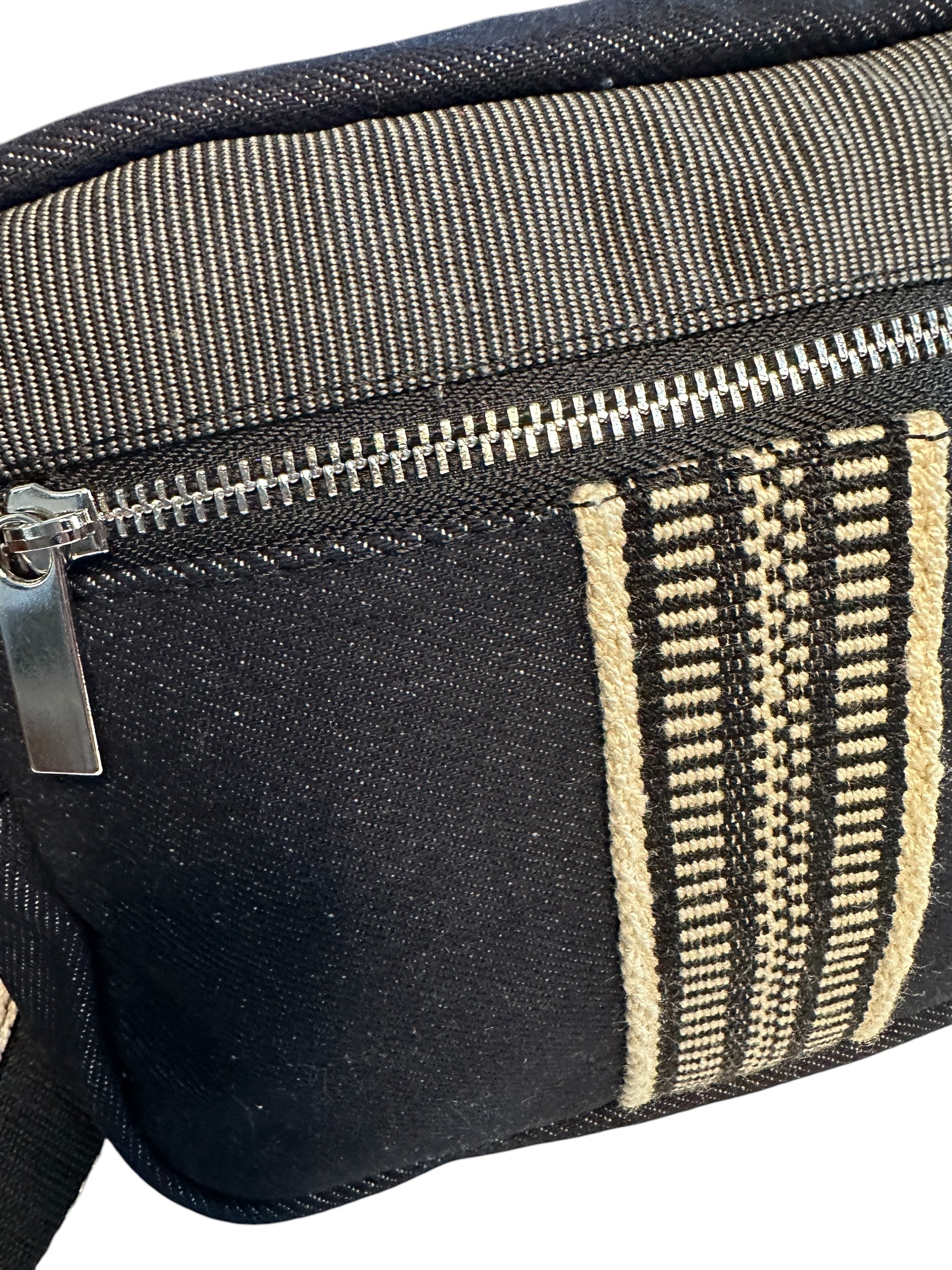 Black denim sling bag with colorful web.