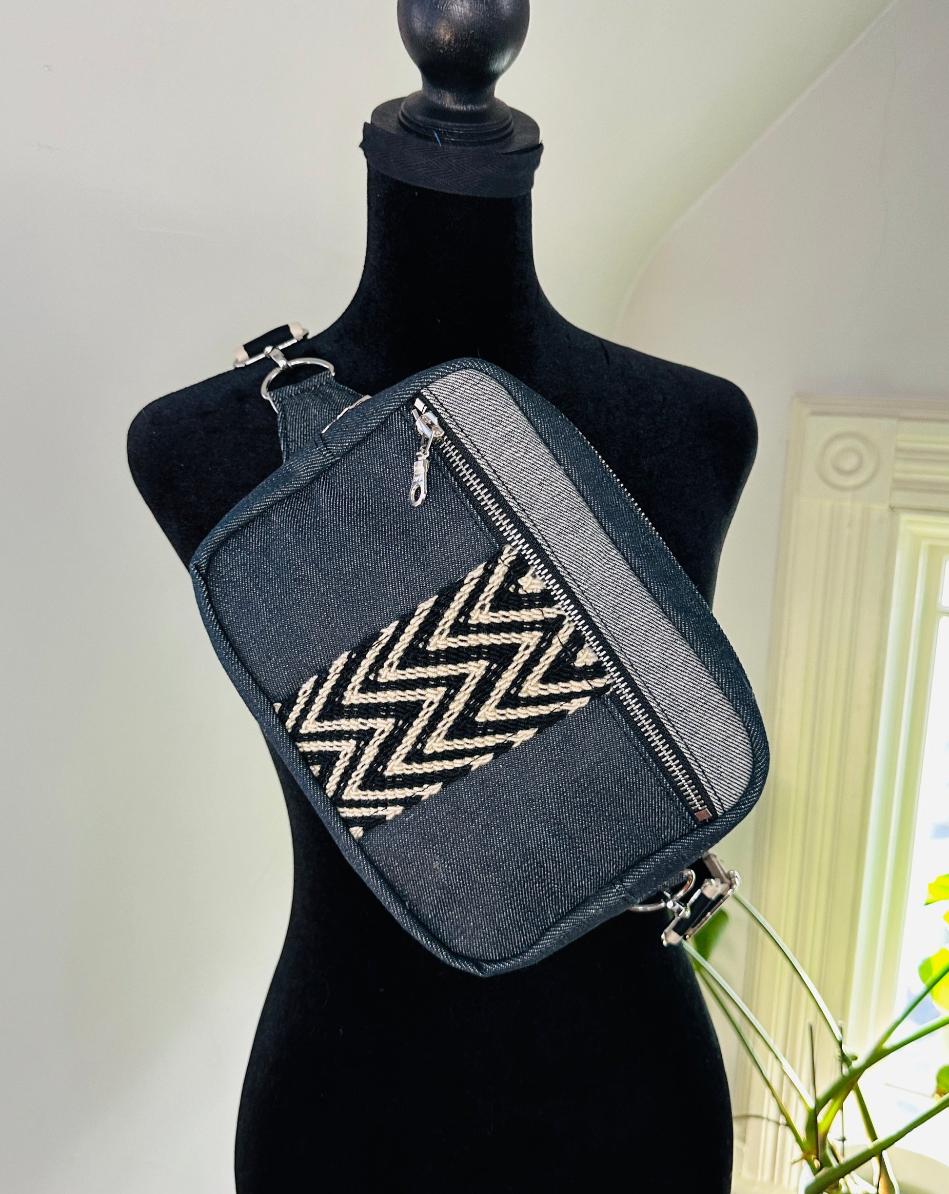 Black denim sling crossbody travel bag.