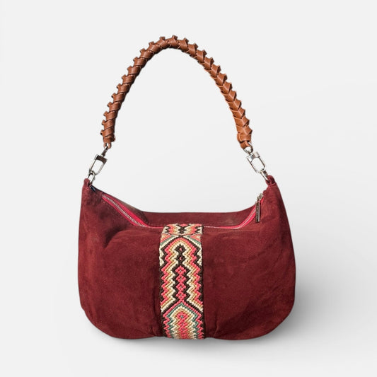 Red handbag with a decorative strap on a white background