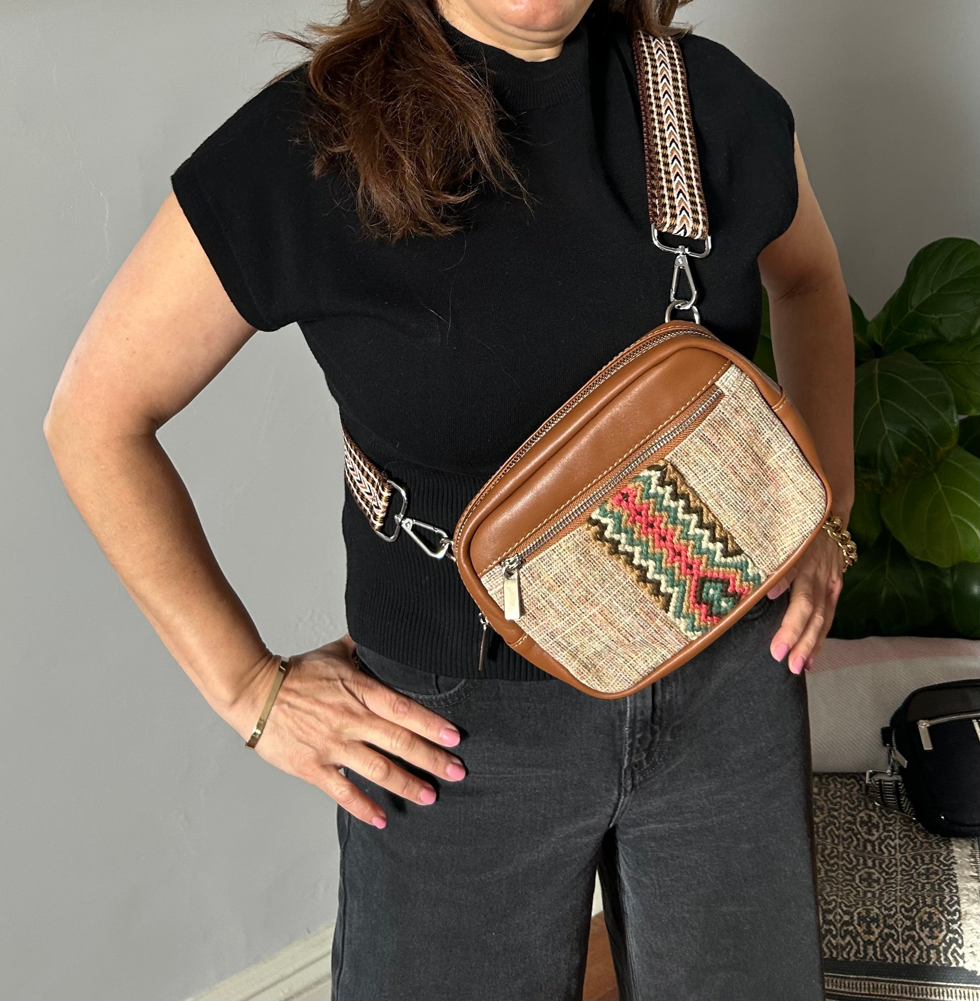 Leather and fabric sling bag with colorful web.
