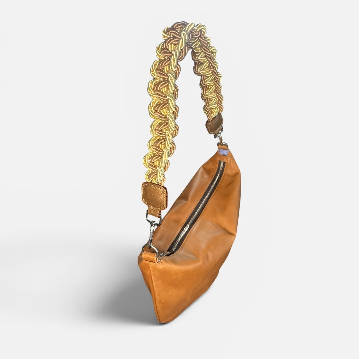 Medium caramel leather slouchy shoulder bag featuring a handwoven cord braided shoulder strap, soft silhouette, and spacious interior for everyday use.