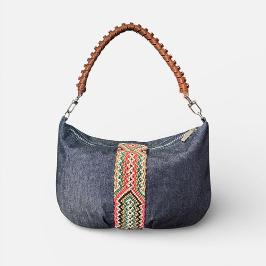 Denim handbag with a colorful strap on a white background
