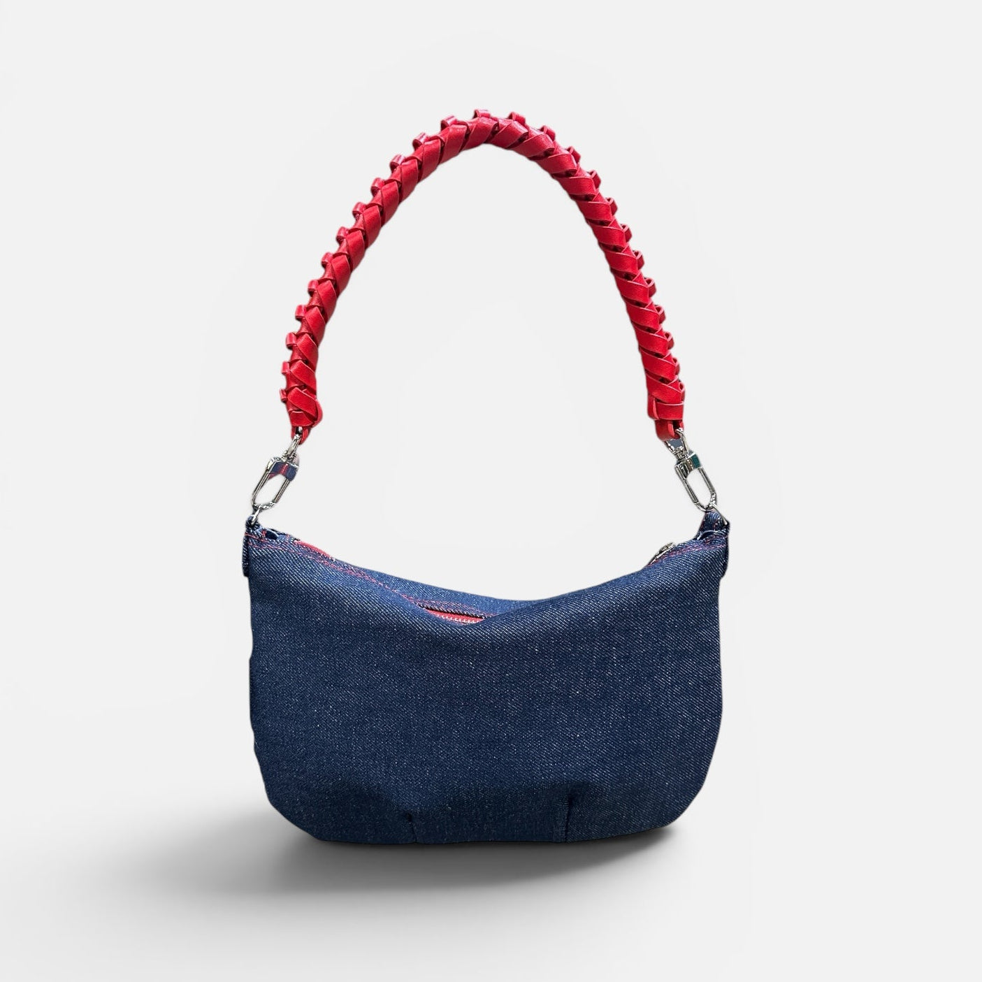 Blue handbag with red handle on a white background