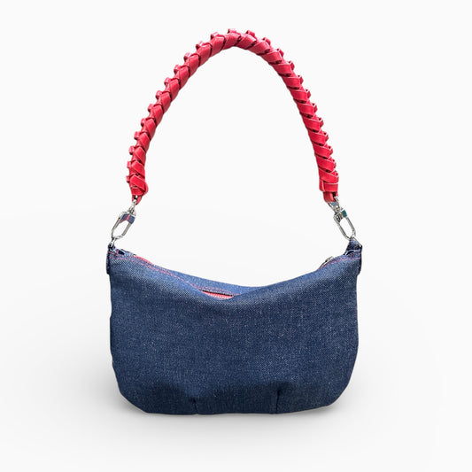 Blue handbag with a red braided handle on a white background