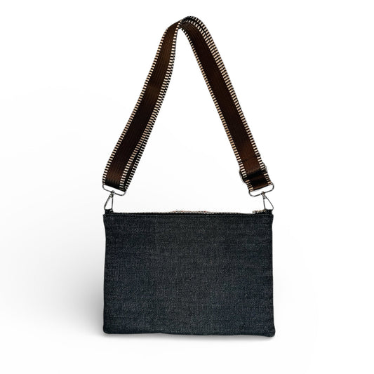 Black denim crossbody bag with brown strap on a white background