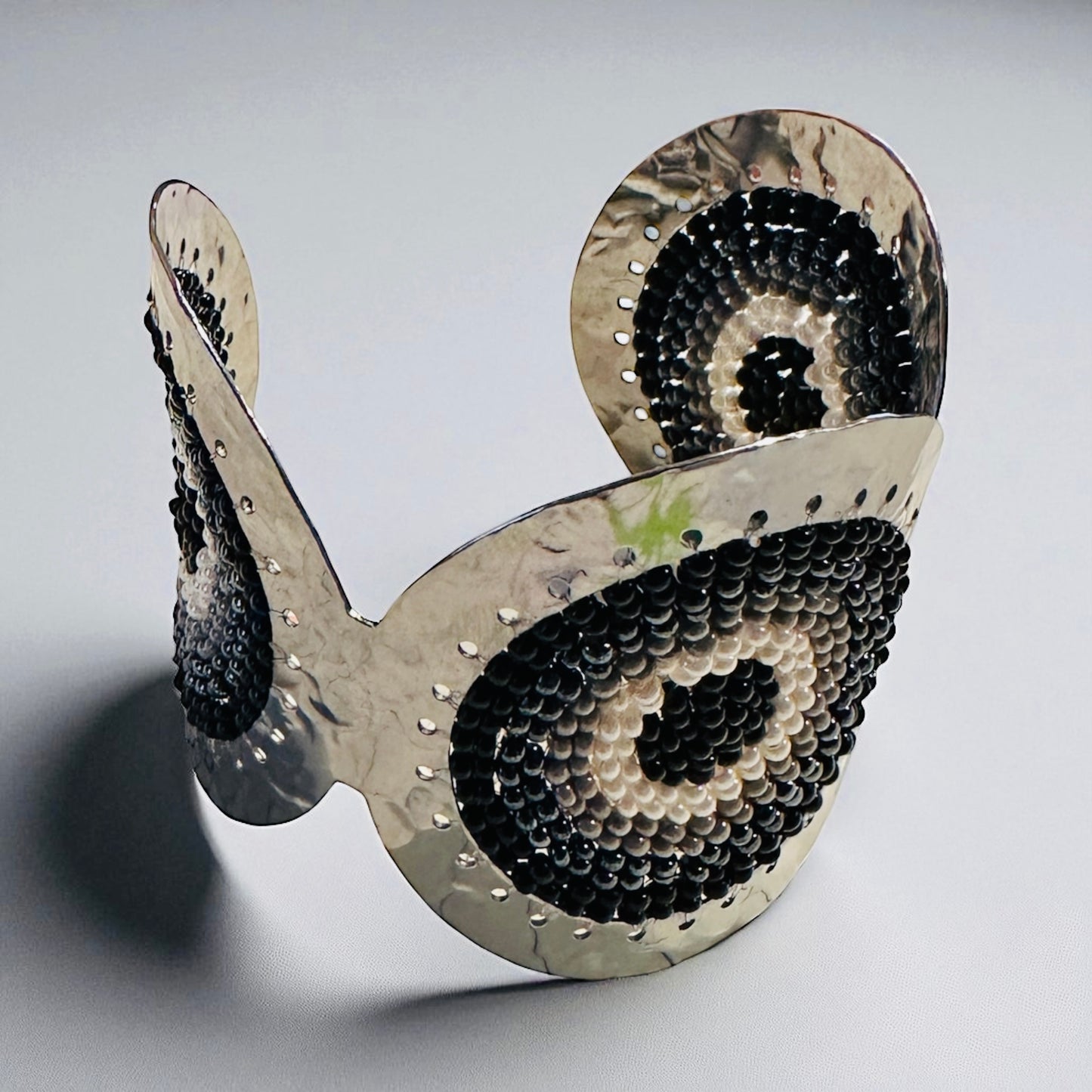 Cuff bracelet with black and white pattern on a gray background