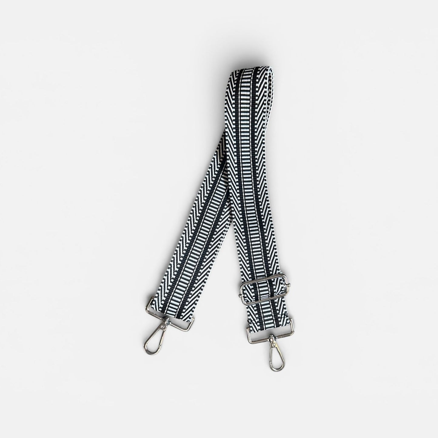 Black and white striped bag strap on a light gray background