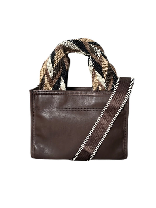 Brown leather handbag with a geometric patterned handle on a white background