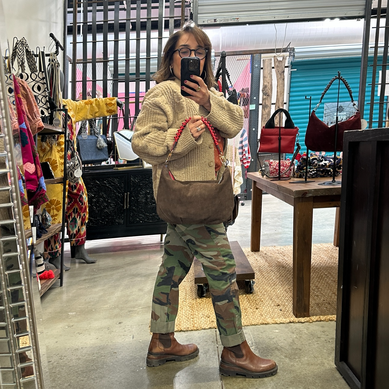 Person taking a mirror selfie in a store with various items in the background