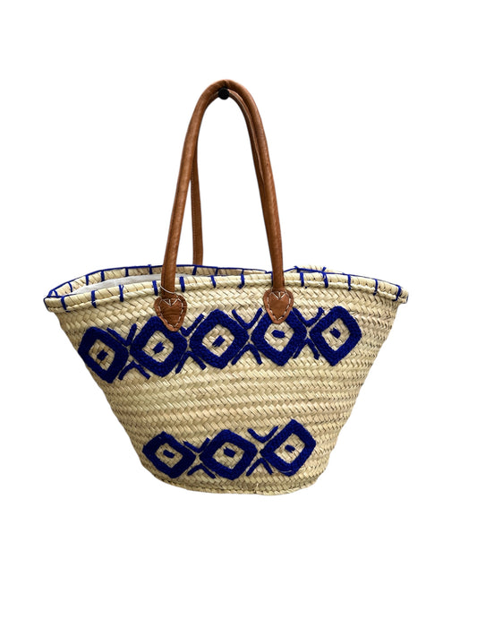 Woven basket with blue geometric patterns and brown handles on a white background