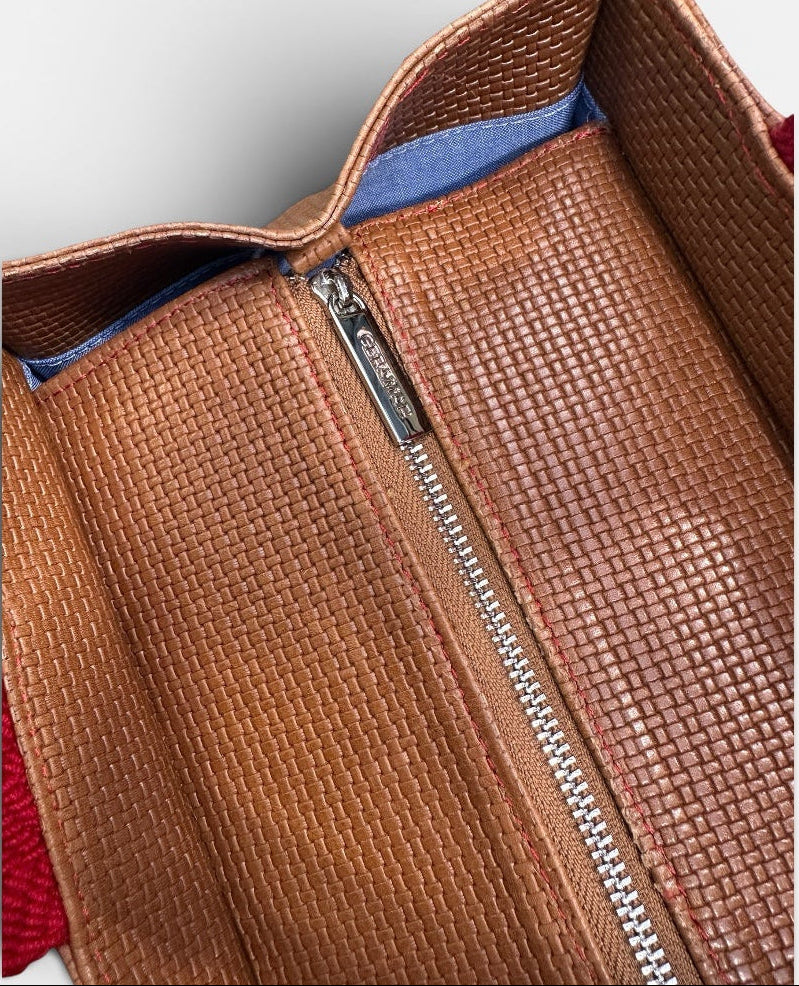 Brown leather bag with zipper on a light gray background