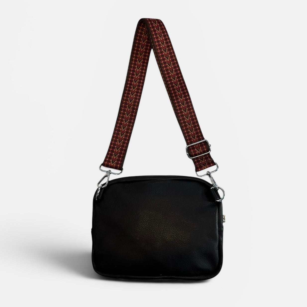 Black handbag with a brown checkered strap on a light gray background