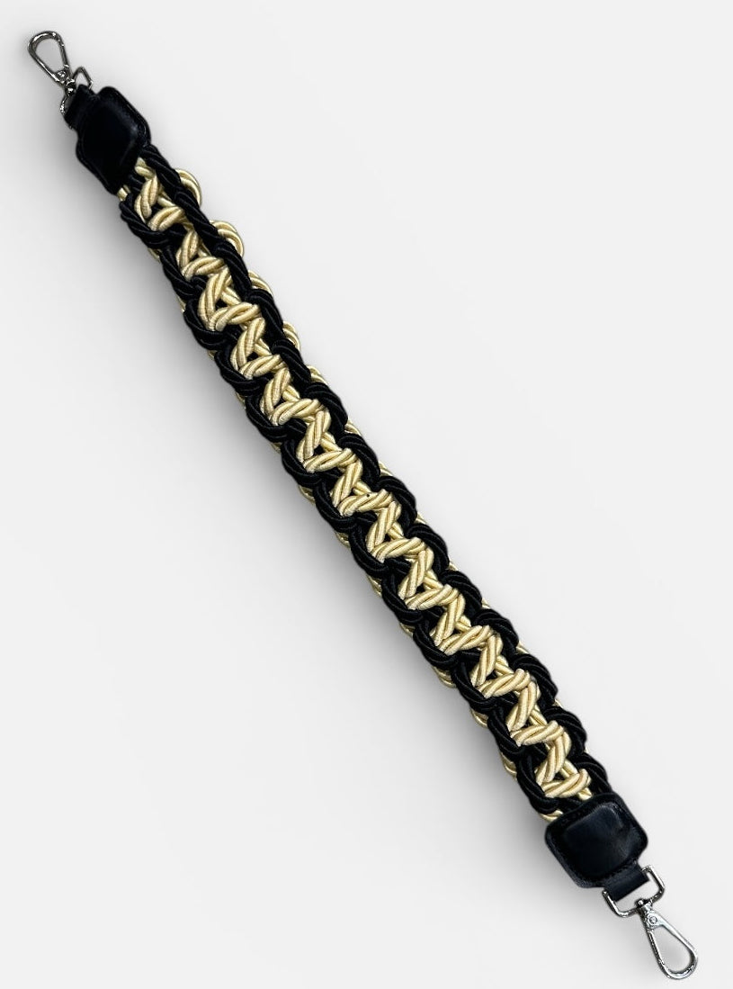 Black and gold braided strap with metal hooks on a white background