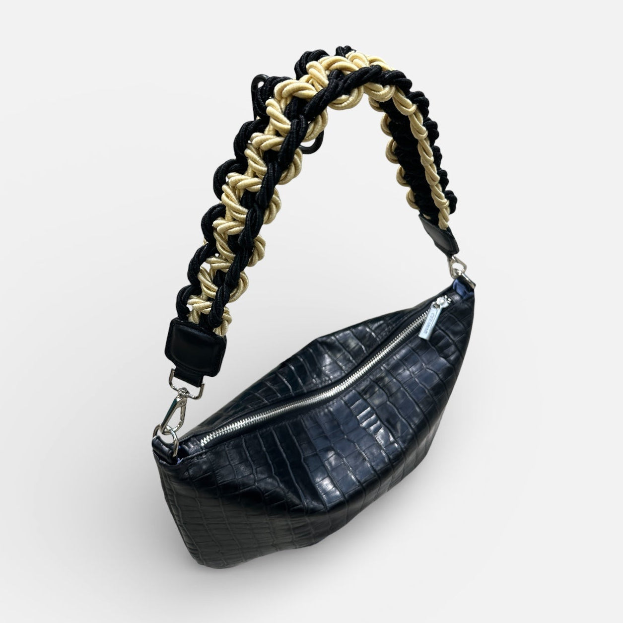 Black leather waist bag with braided handle on a white background