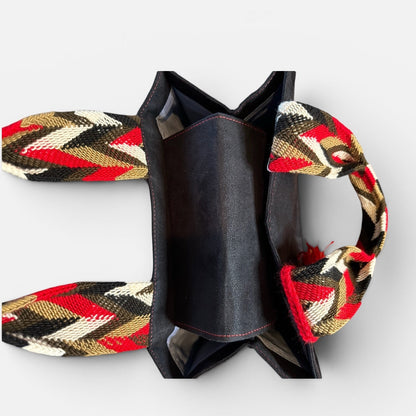 Black bow tie with red, yellow, and black patterned straps on a white background