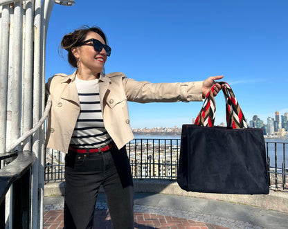 Black faux suede tote bag featuring vibrant handwoven Wayuu straps, blending Colombian craftsmanship with a modern everyday design.