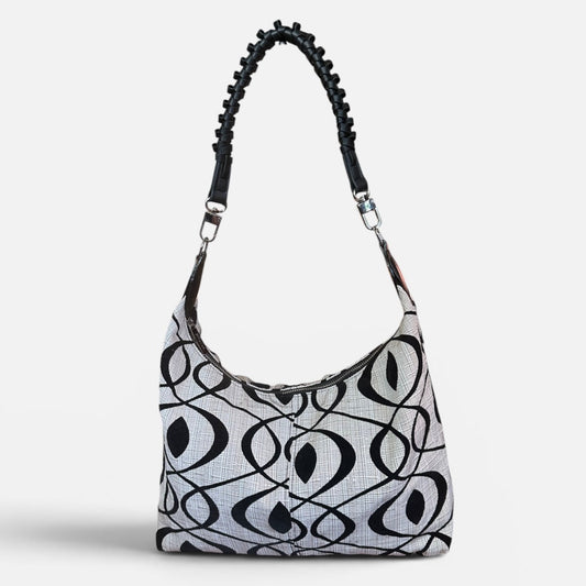 Medium black and cream slouchy shoulder bag featuring a handwoven Wayuu strap, spacious interior, and artisan craftsmanship for everyday style.