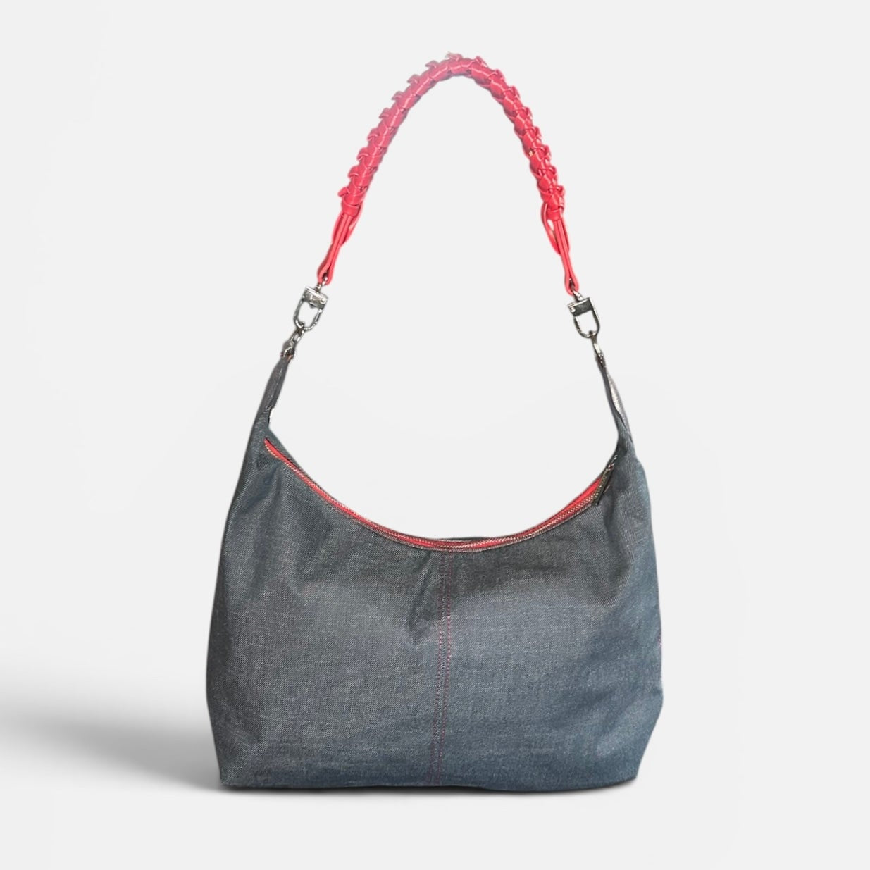 Medium blue denim slouchy shoulder bag featuring a red braided shoulder strap, relaxed silhouette, and spacious interior for everyday use.