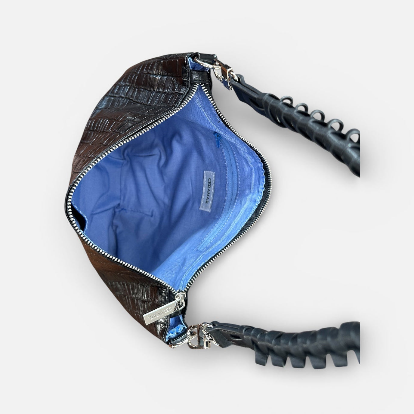 Black textured handbag with blue interior on a white background