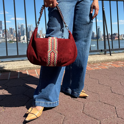 Burgundy suede hobo shoulder bag featuring a handwoven Wayuu decorative strap with leather trim, a soft slouchy silhouette, and a spacious interior for everyday use.