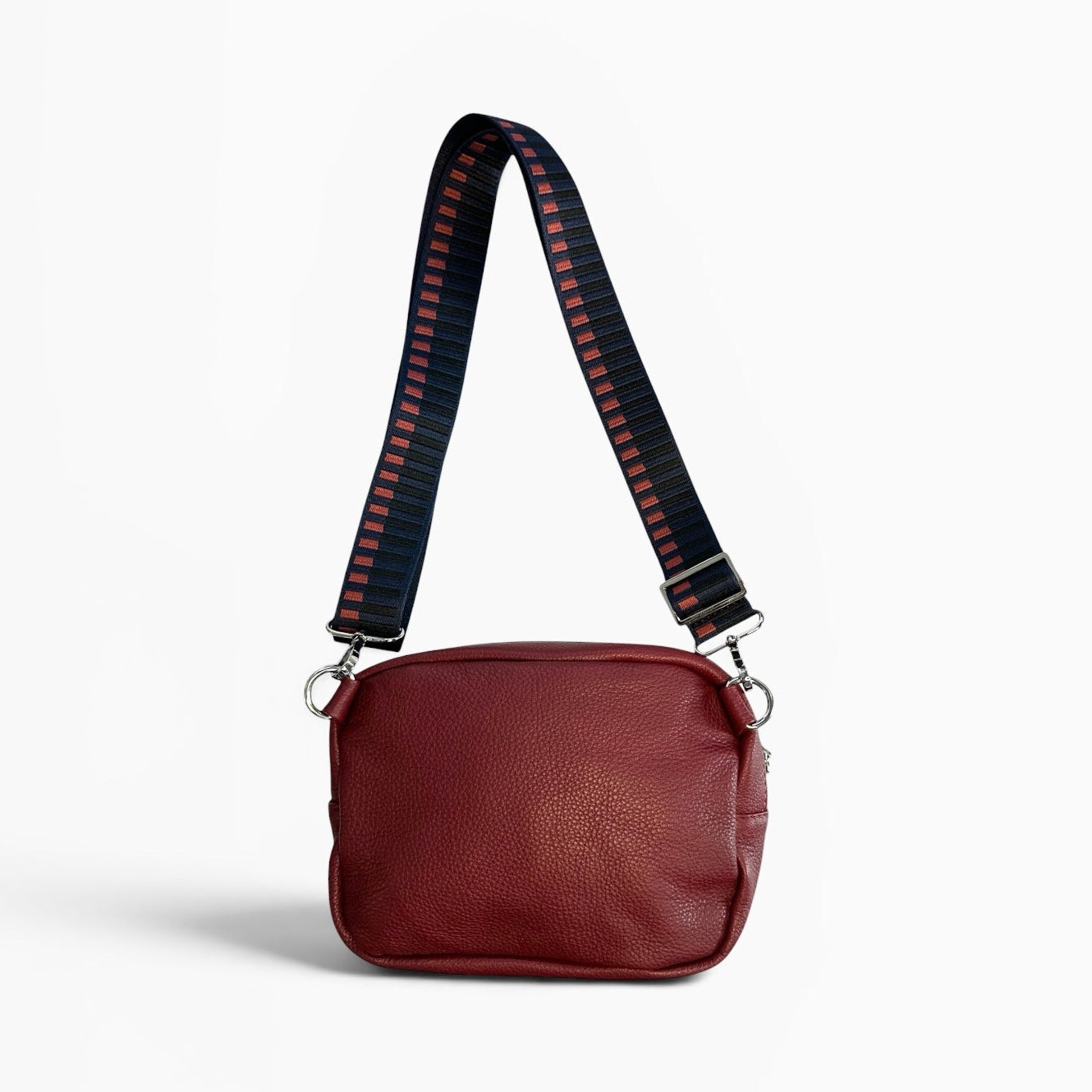 Brown leather handbag with a black and red striped strap on a white background