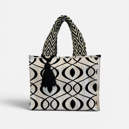 Black and white patterned tote bag with a tassel on a white background