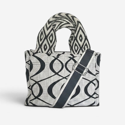 Small Jules tote in cream and black swirl fabric featuring handwoven Wayuu strap handles, a removable crossbody strap, and a structured design for everyday use.