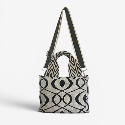 Small Jules tote in cream and black swirl fabric featuring handwoven Wayuu strap handles, a removable crossbody strap, and a structured design for everyday use.