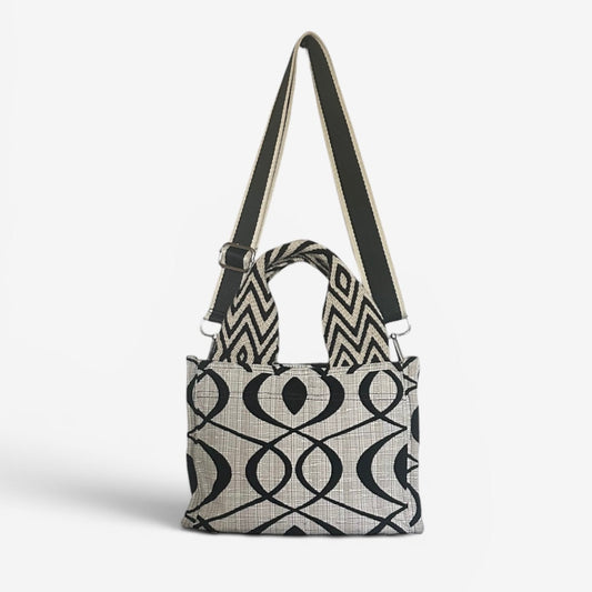 Small Jules tote in cream and black swirl fabric featuring handwoven Wayuu strap handles, a removable crossbody strap, and a structured design for everyday use.