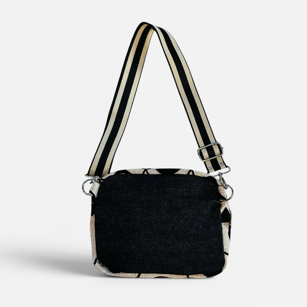 Black handbag with a strap on a white background