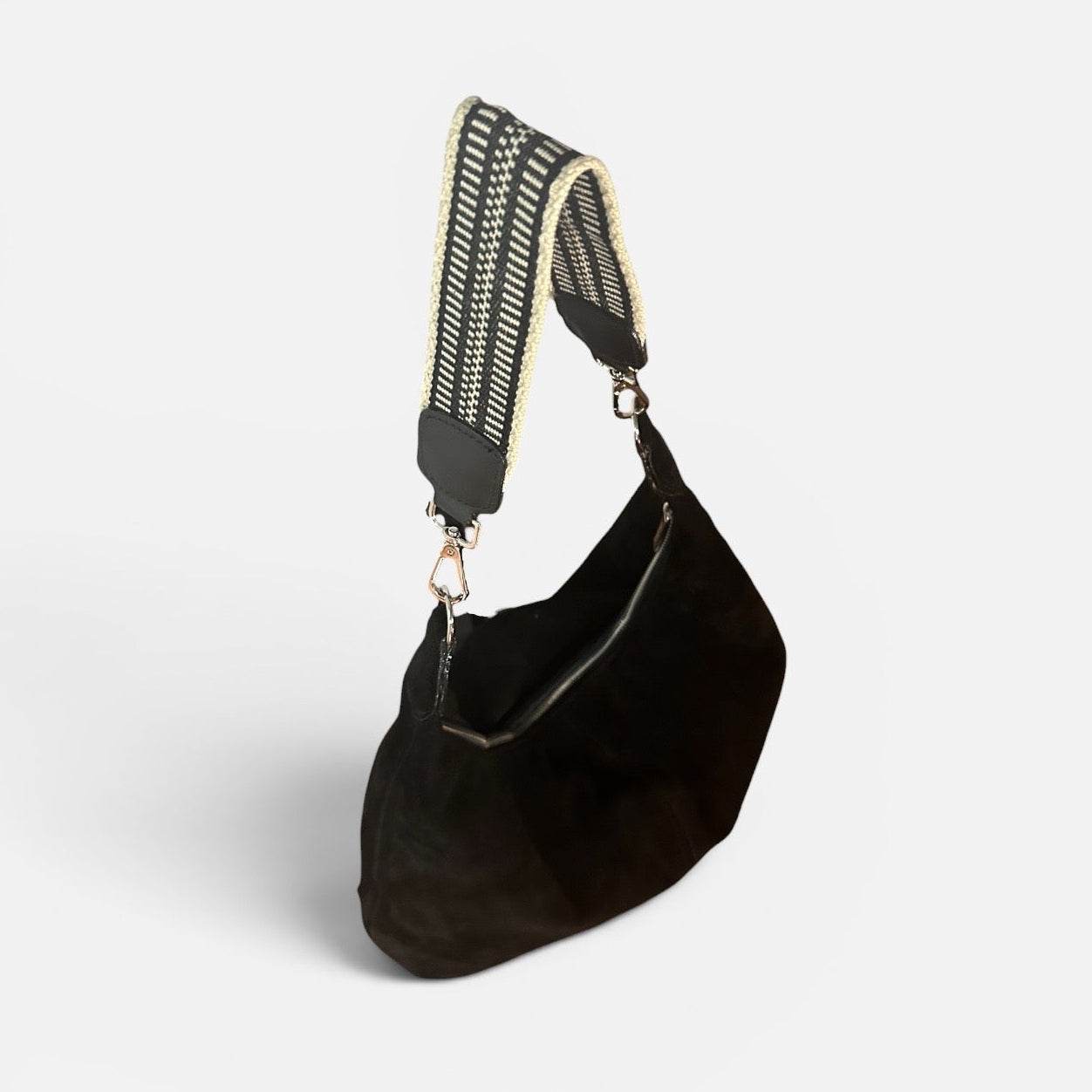 Large black suede slouchy shoulder bag featuring a handwoven Wayuu strap, spacious interior, and artisan craftsmanship for work, travel, and everyday style.