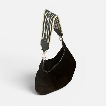 Large black suede slouchy shoulder bag featuring a handwoven Wayuu strap, spacious interior, and artisan craftsmanship for work, travel, and everyday style.