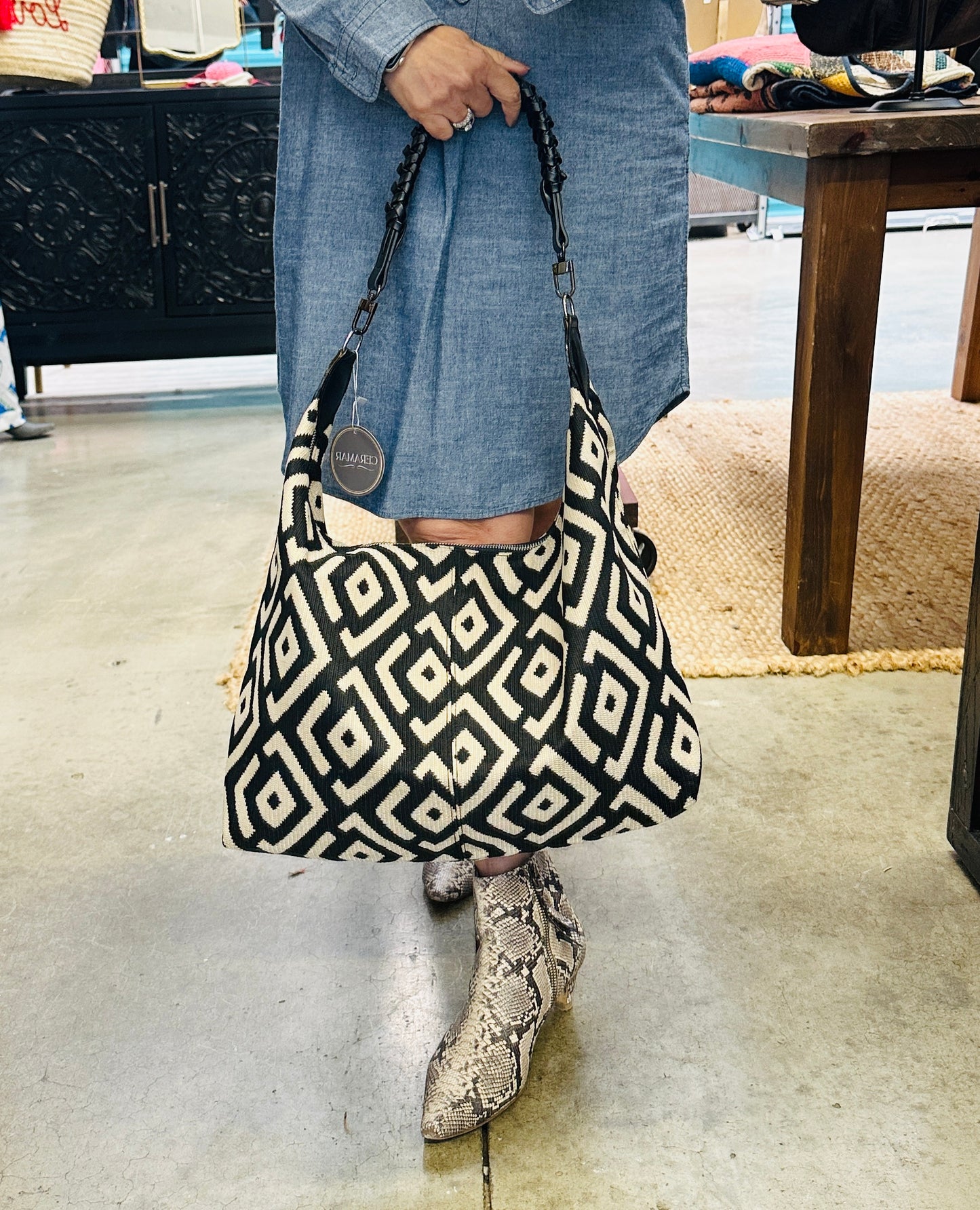 Handcrafted black and cream shoulder bag with a chic slouchy silhouette, combining modern design with artisan craftsmanship.