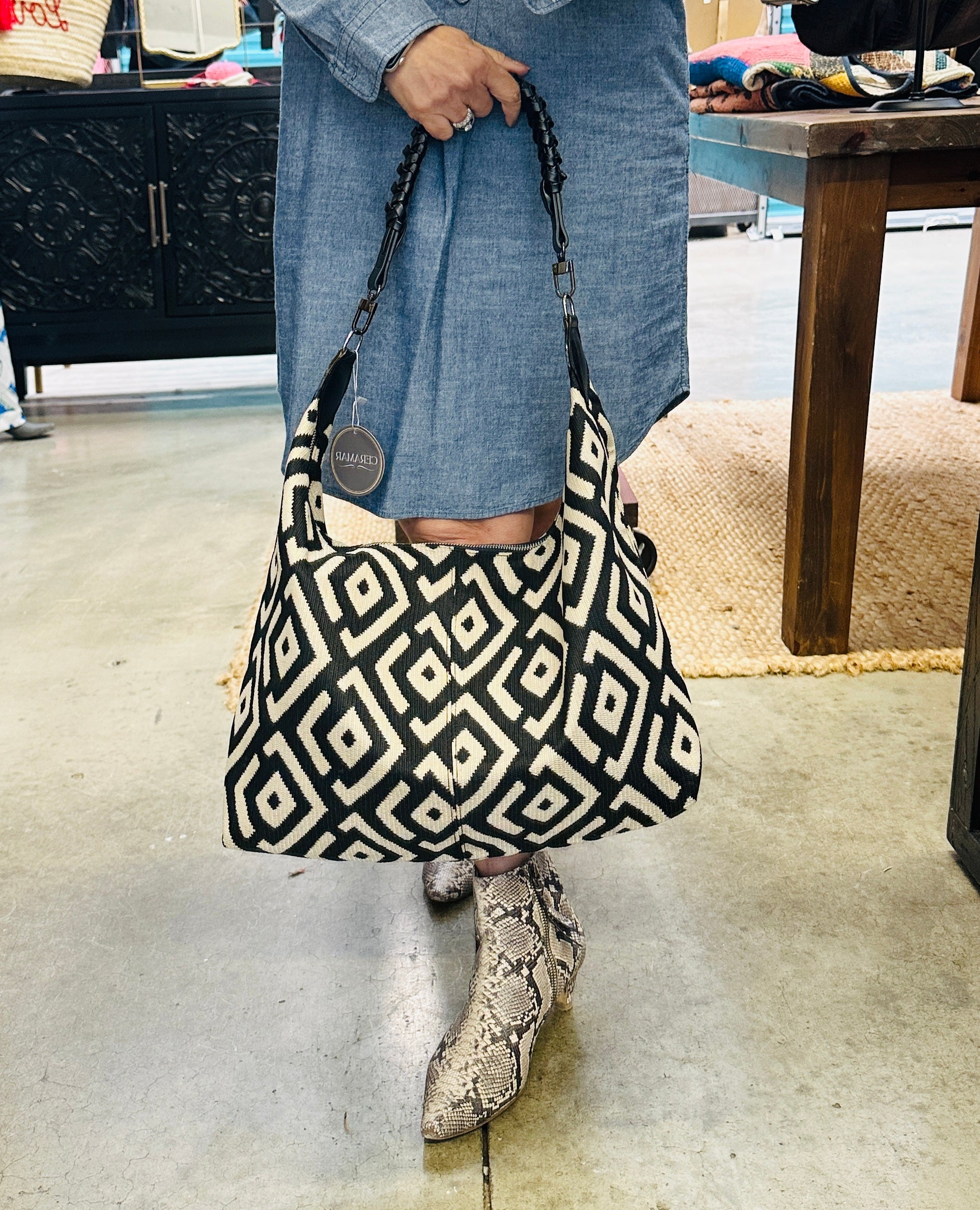 Handcrafted black and cream shoulder bag with a chic slouchy silhouette, combining modern design with artisan craftsmanship.
