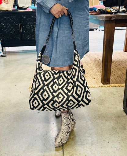 Handcrafted black and cream shoulder bag with a chic slouchy silhouette, combining modern design with artisan craftsmanship.