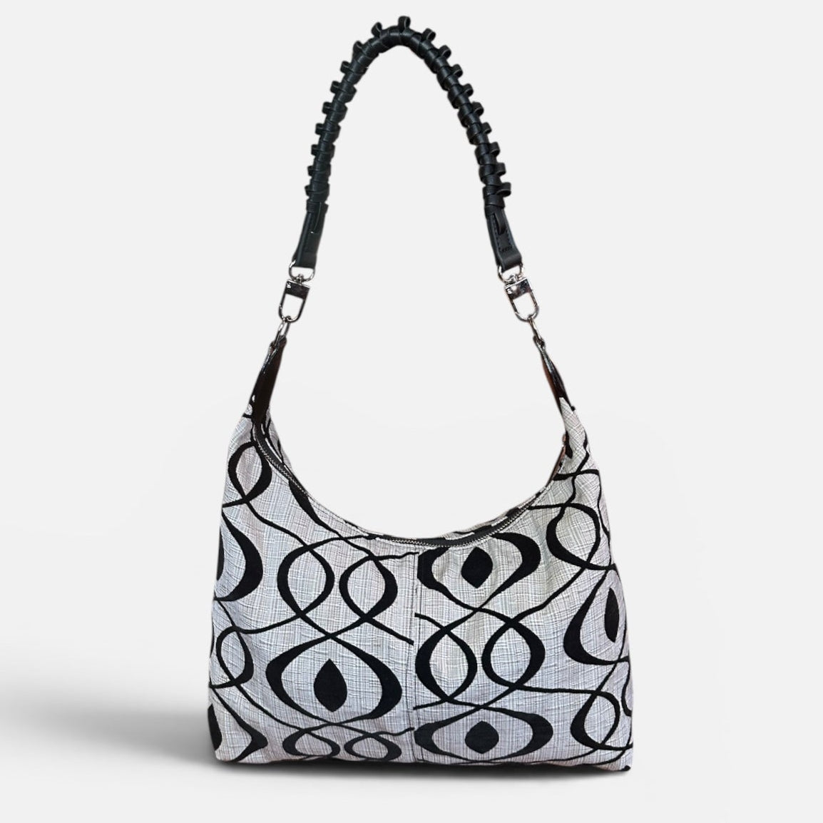 Medium black and cream slouchy shoulder bag featuring a handwoven braided strap, spacious interior, and artisan craftsmanship for everyday style.