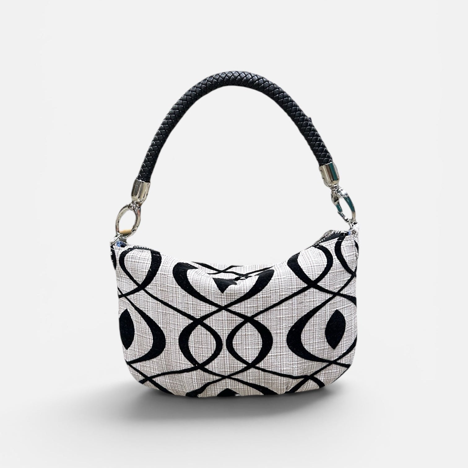 Black and cream patterned handbag on a light gray background 