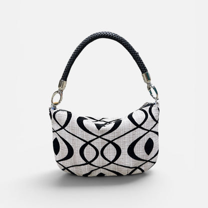 Black and cream patterned handbag on a light gray background 