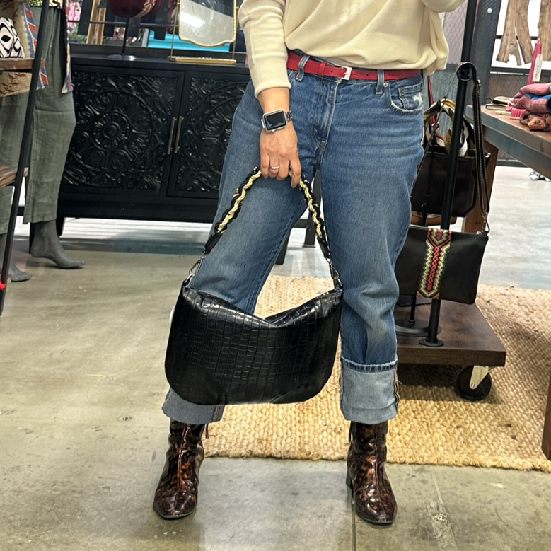 Black embossed croco leather hobo shoulder bag featuring a handwoven cord shoulder strap, soft silhouette, and spacious interior for everyday use.