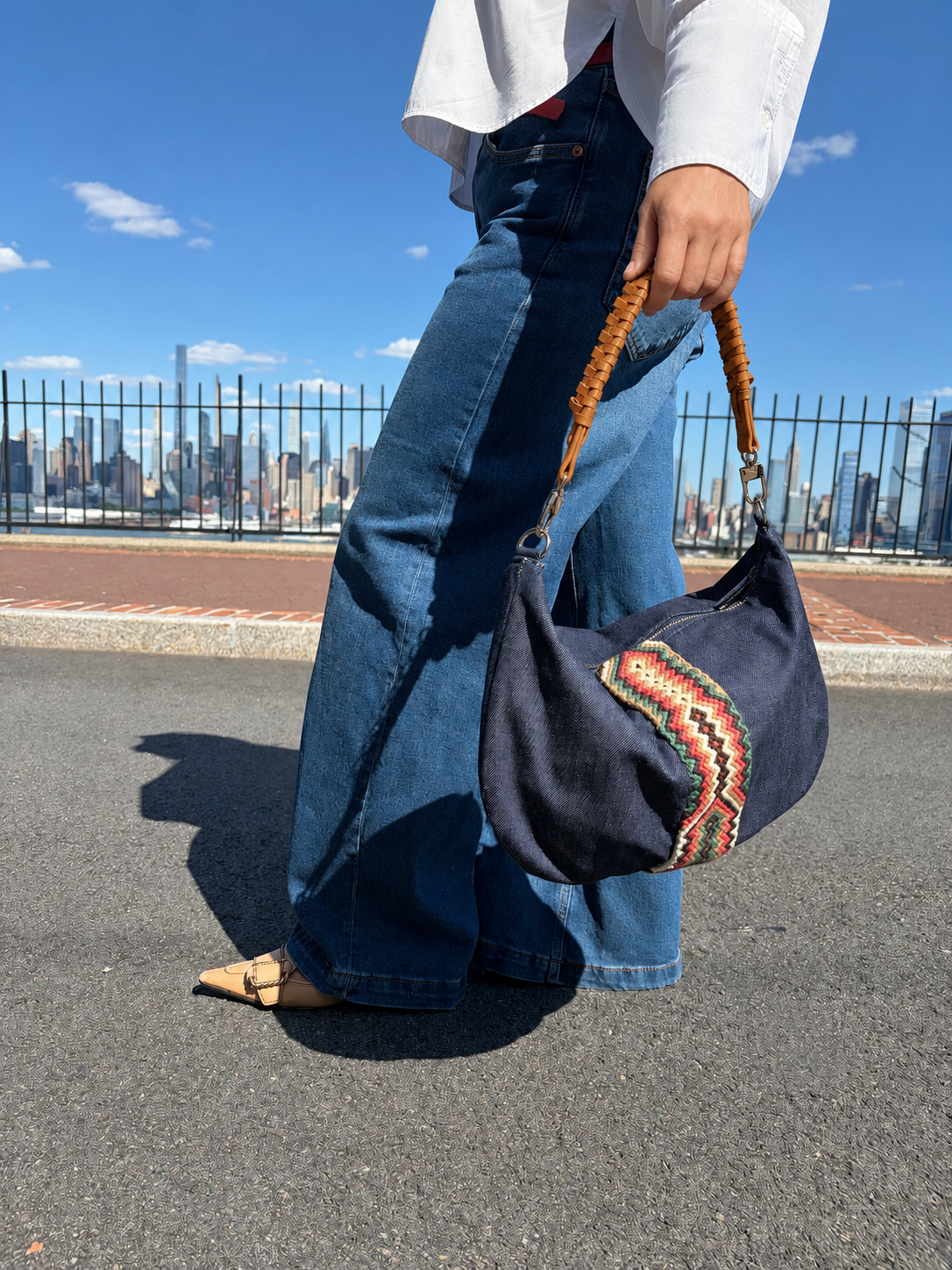 Denim hobo shoulder bag featuring a handwoven Wayuu decorative strap with leather trim, a relaxed silhouette, and a spacious interior for everyday use.
