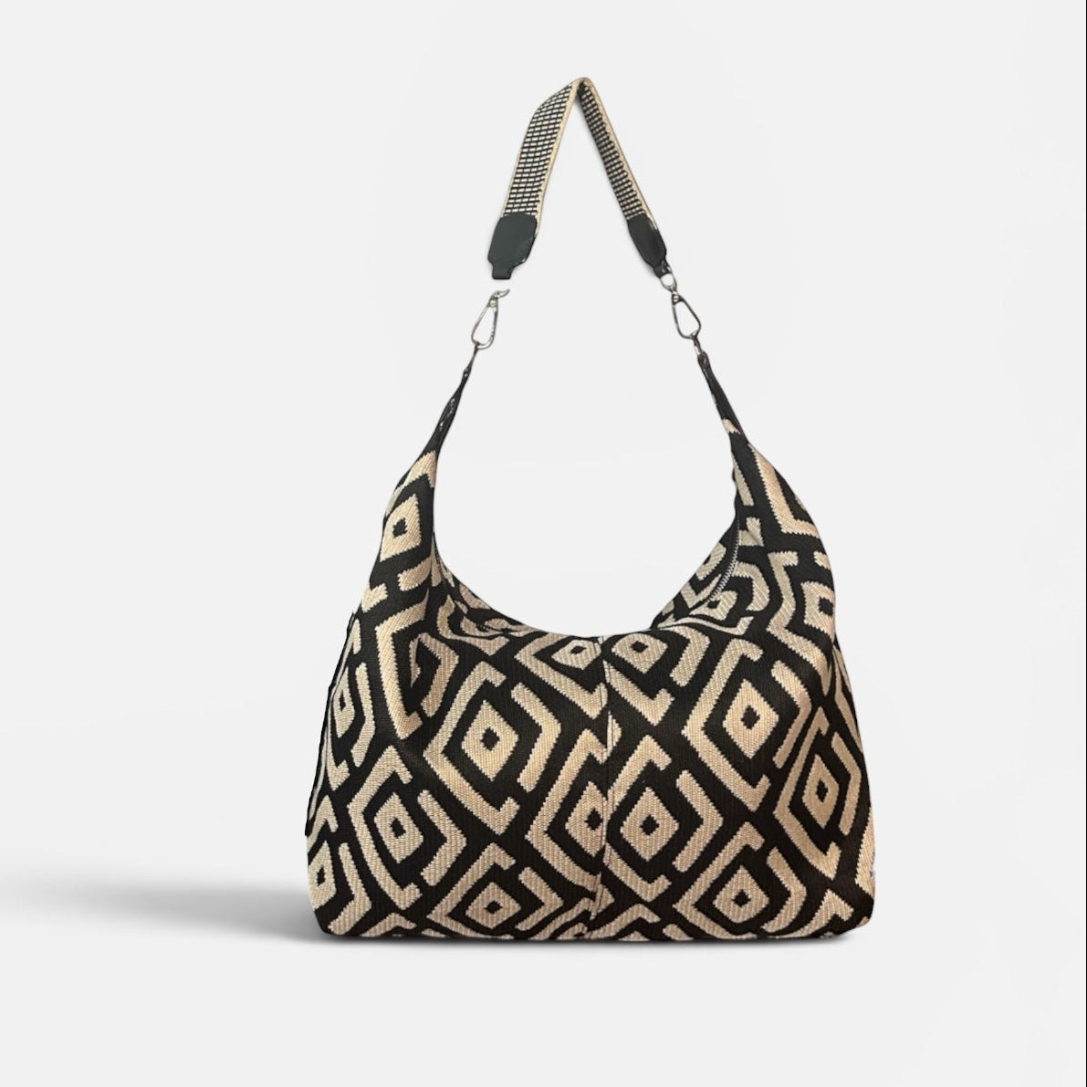 Large black and cream geometric fabric slouchy shoulder bag featuring a handwoven Wayuu strap, spacious interior, and artisanal Colombian-inspired details.