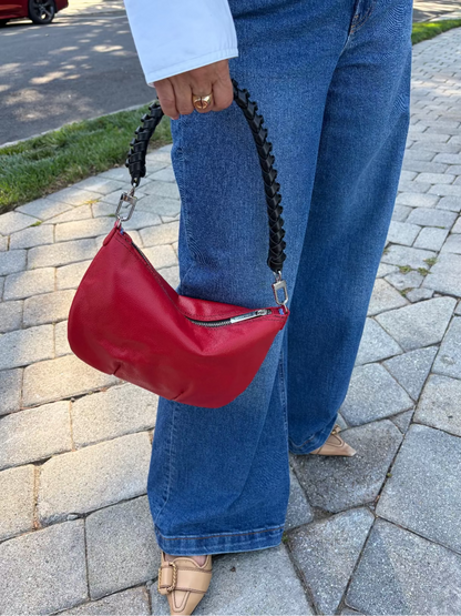 Mini red leather hobo shoulder bag featuring a black braided shoulder strap, soft silhouette, and compact design for everyday essentials.
