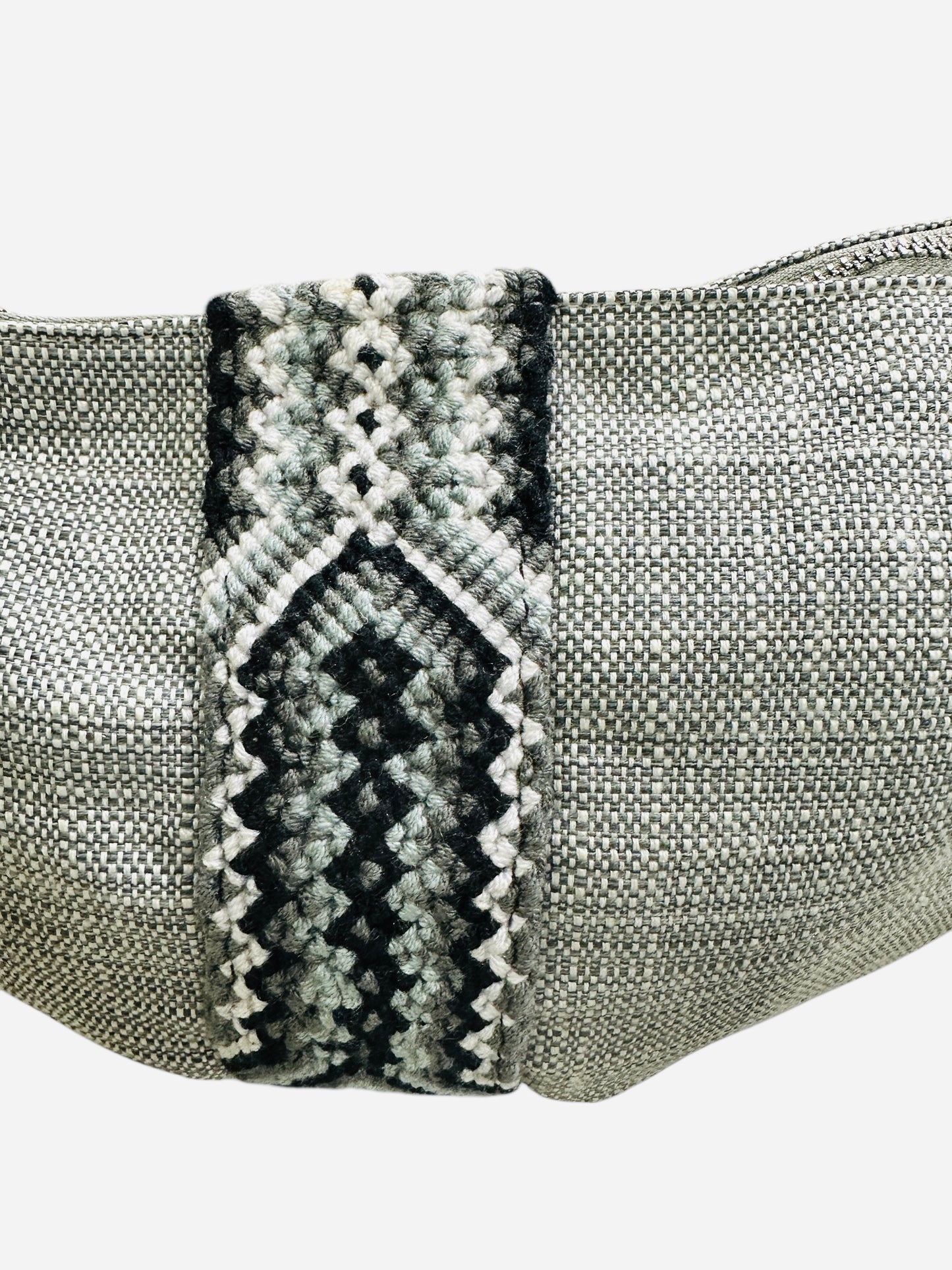Silver mesh pouch with a patterned black and gray strap on a white background