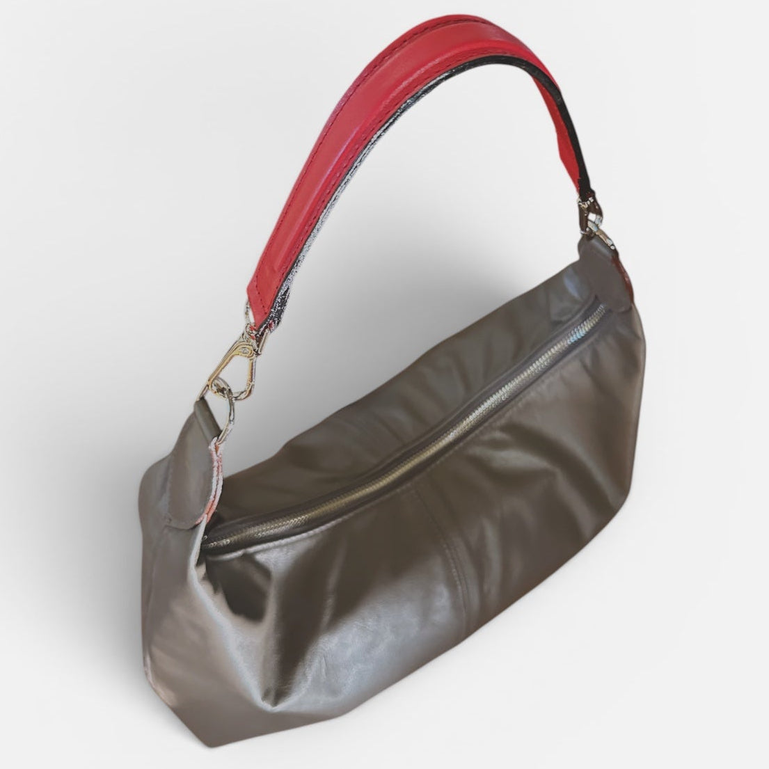 Medium taupe leather slouchy shoulder bag featuring a contrasting red leather shoulder strap, soft silhouette, and spacious interior for everyday wear.