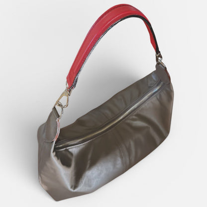 Medium taupe leather slouchy shoulder bag featuring a contrasting red leather shoulder strap, soft silhouette, and spacious interior for everyday wear.