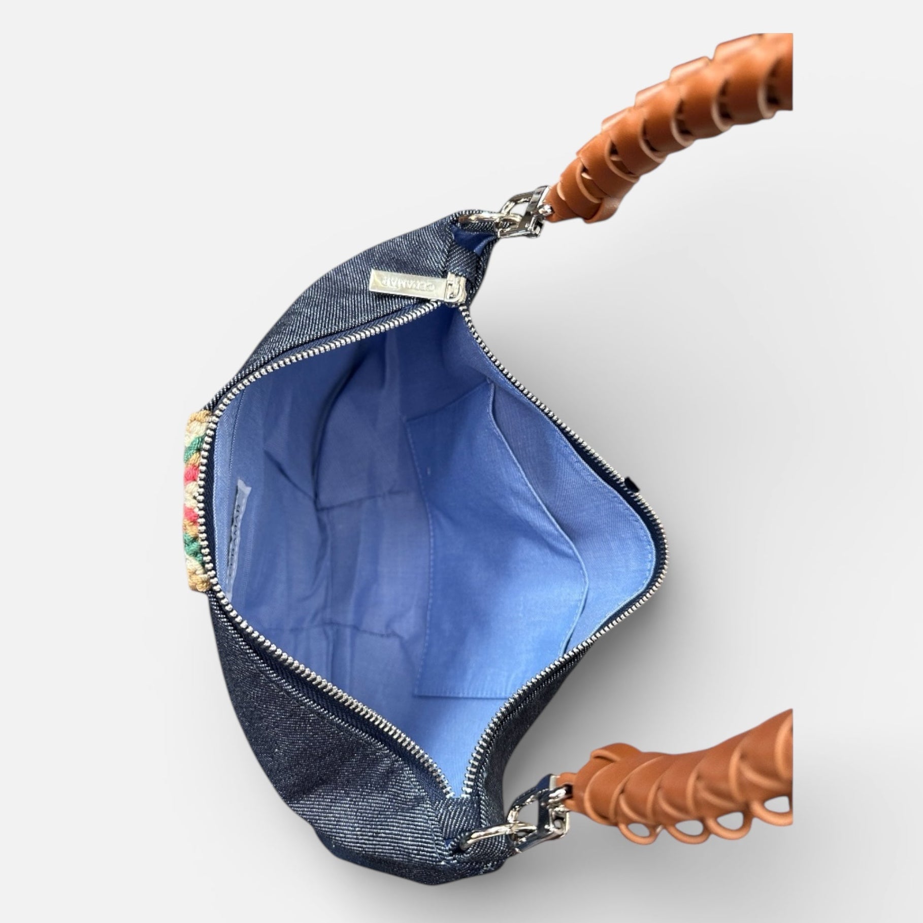 Blue denim pouch with a brown handle on a white background