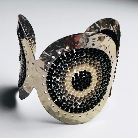 Decorative bracelet with black and silver design on a white background