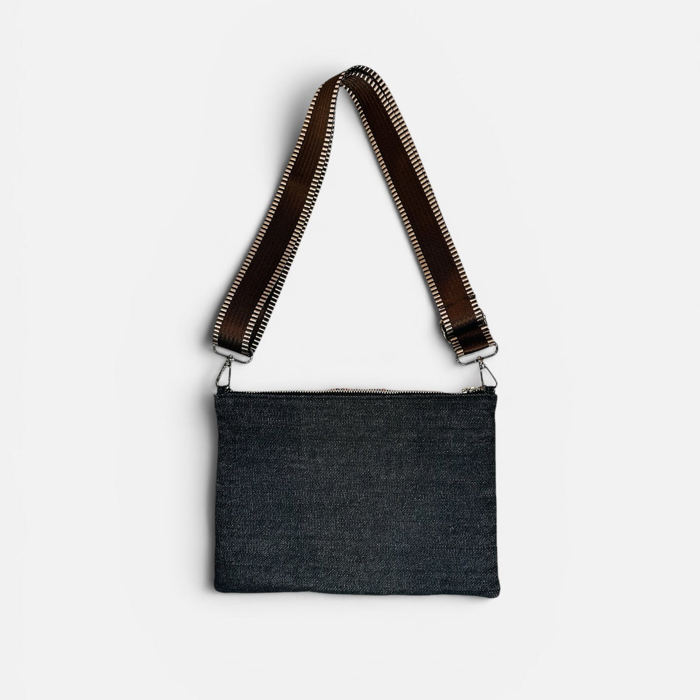 Black crossbody bag with brown strap on a white background